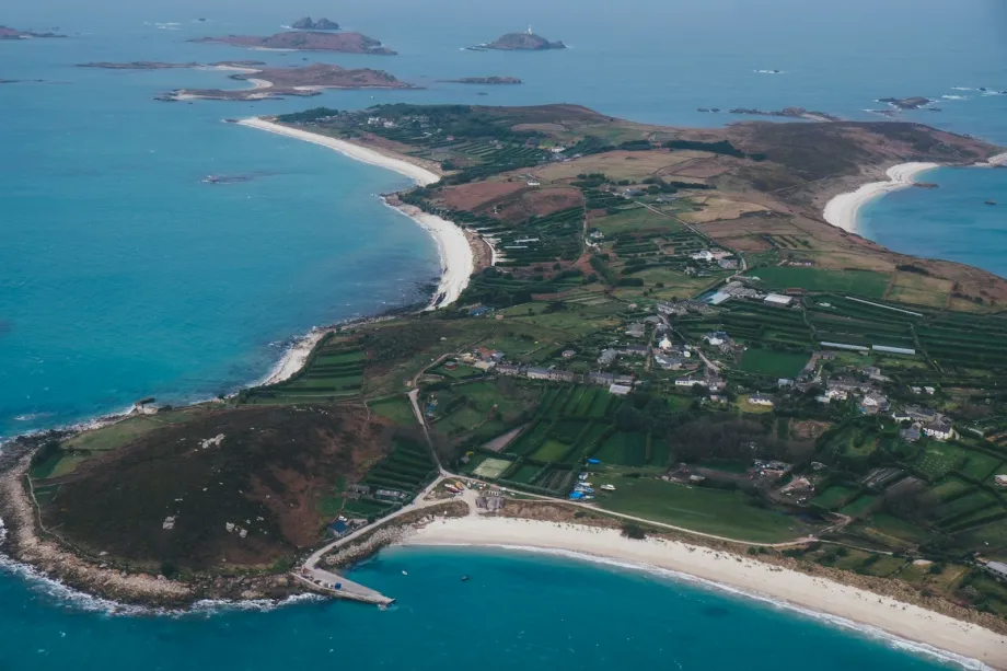 Aerial view of a low island ringed by shallows and clear sea