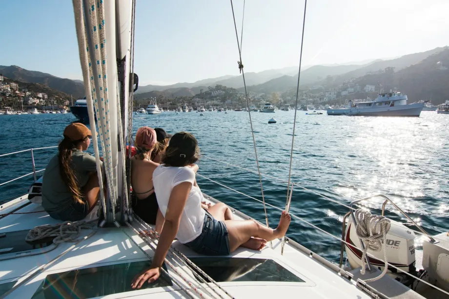 Crew sitting on the foredeck of a sailing yacht under way